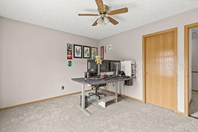 office featuring a textured ceiling, ceiling fan, carpet, and baseboards