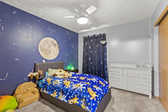 bedroom featuring carpet, baseboards, ceiling fan, and a textured ceiling