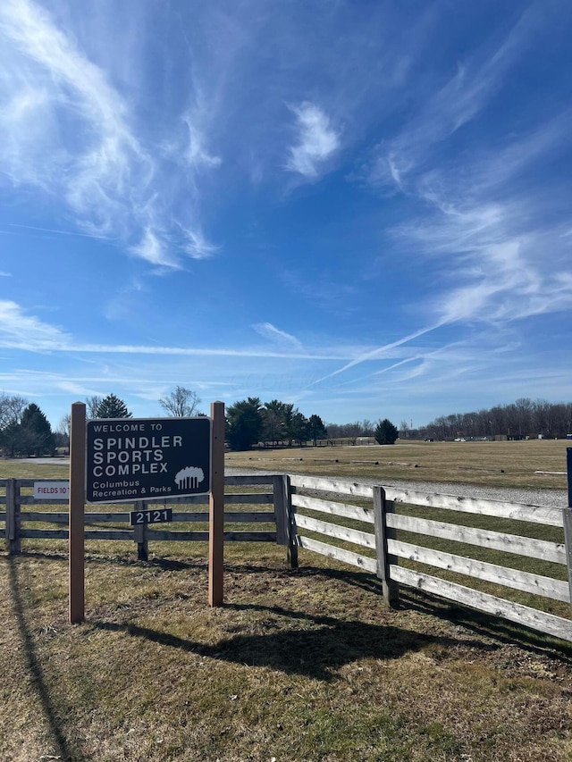 view of gate with fence and a rural view