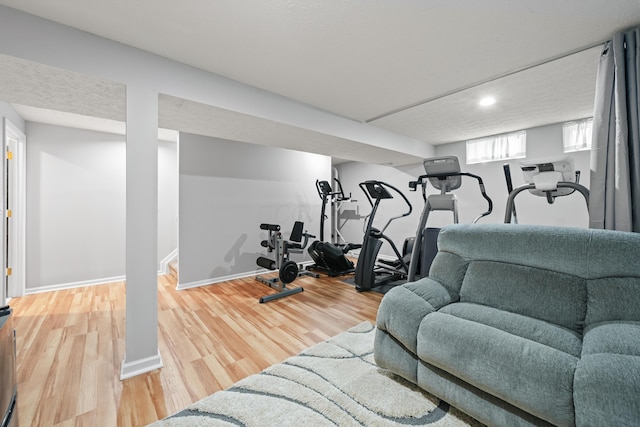 workout area with baseboards and wood finished floors