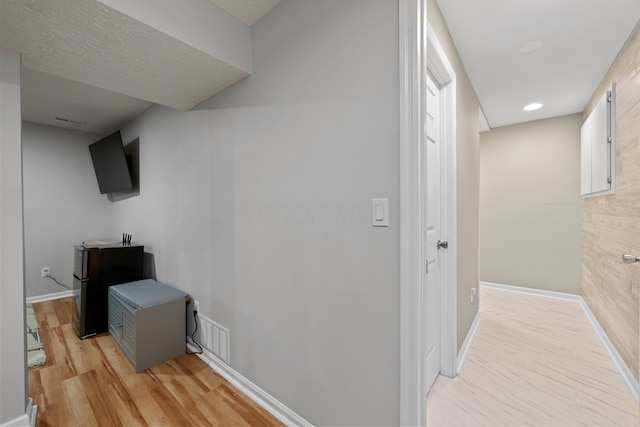 hallway with recessed lighting, baseboards, visible vents, and light wood finished floors