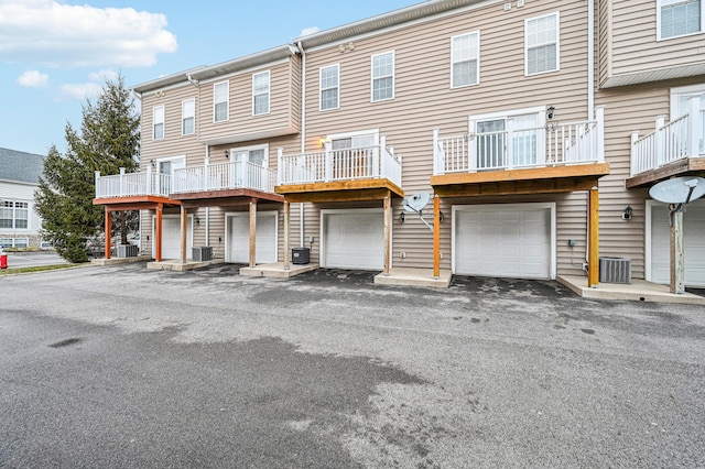 view of property with a garage and central air condition unit