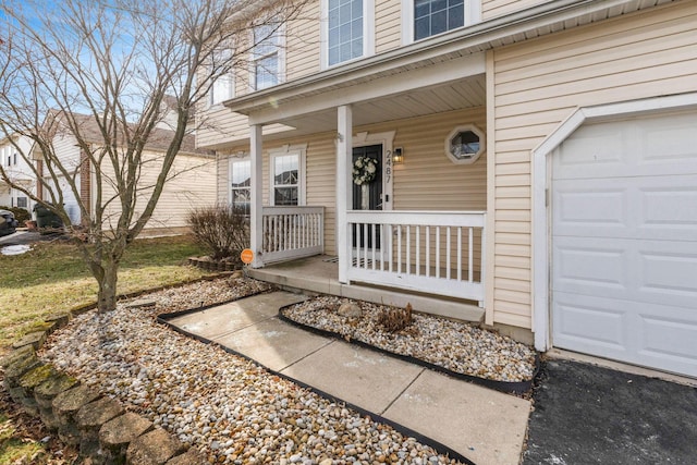 view of exterior entry featuring a garage and covered porch