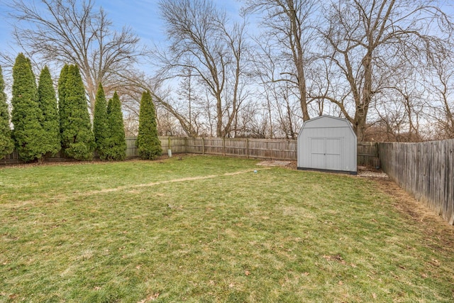 view of yard featuring an outbuilding, a fenced backyard, and a storage shed