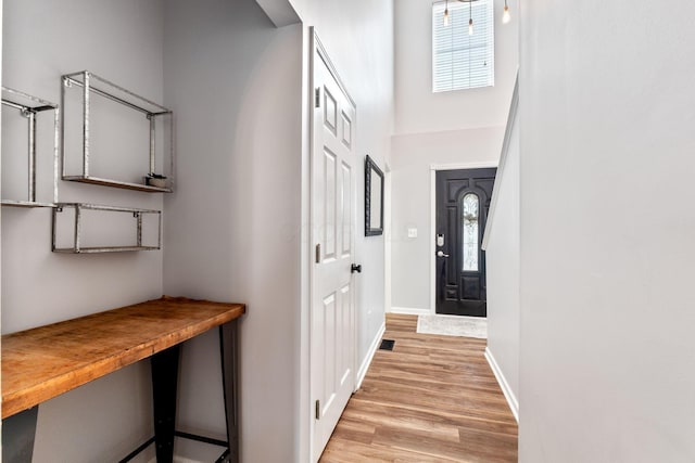 interior space featuring baseboards and light wood finished floors