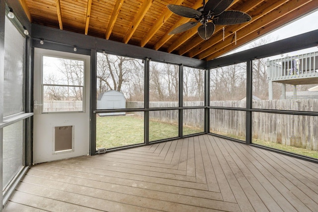 unfurnished sunroom featuring wood ceiling and a ceiling fan