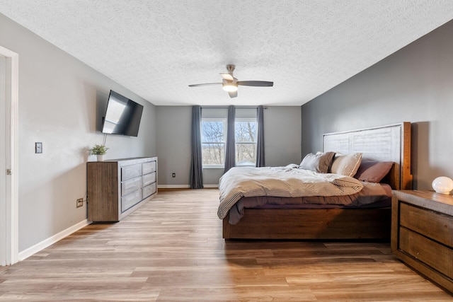 bedroom with light wood-style flooring, baseboards, ceiling fan, and a textured ceiling