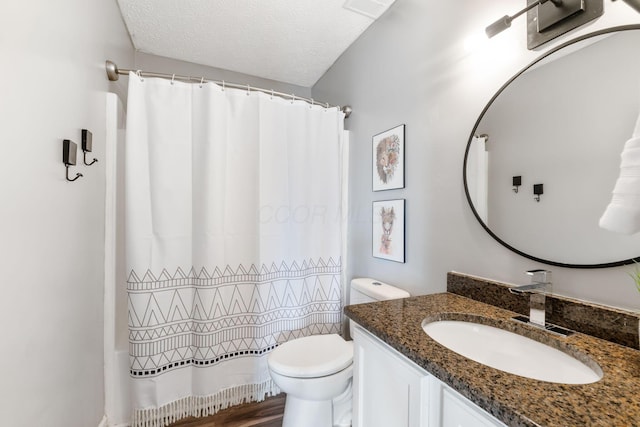 bathroom featuring toilet, a shower with curtain, a textured ceiling, and vanity