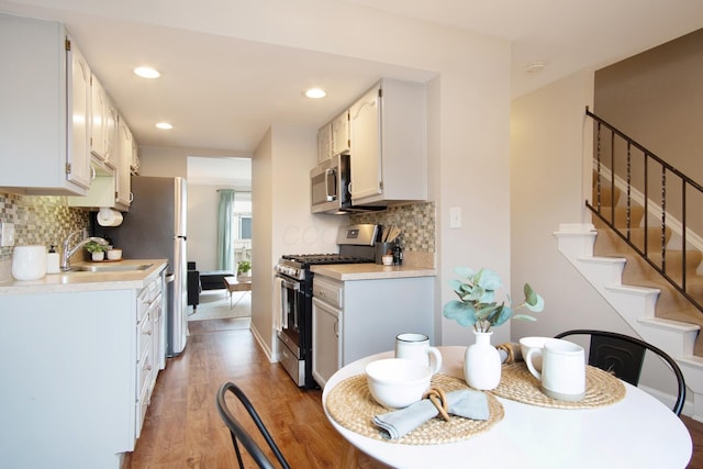 kitchen featuring light wood finished floors, stainless steel appliances, a sink, and light countertops