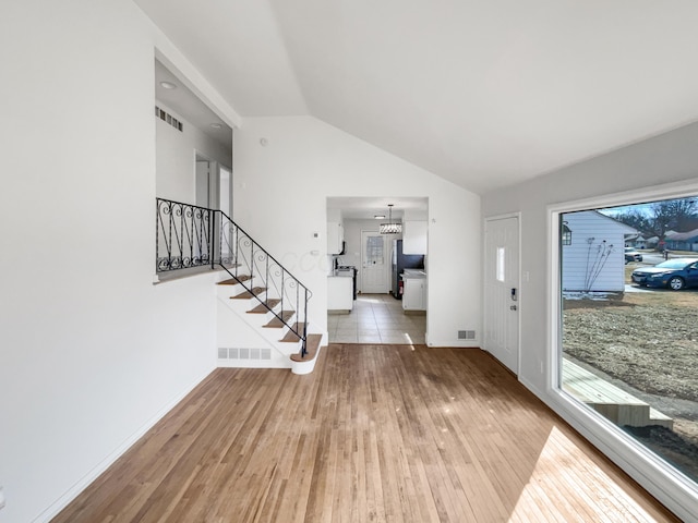 foyer entrance featuring stairs, wood finished floors, and visible vents