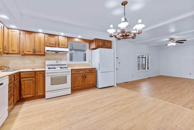 kitchen with white appliances, brown cabinets, extractor fan, light countertops, and light wood-style floors