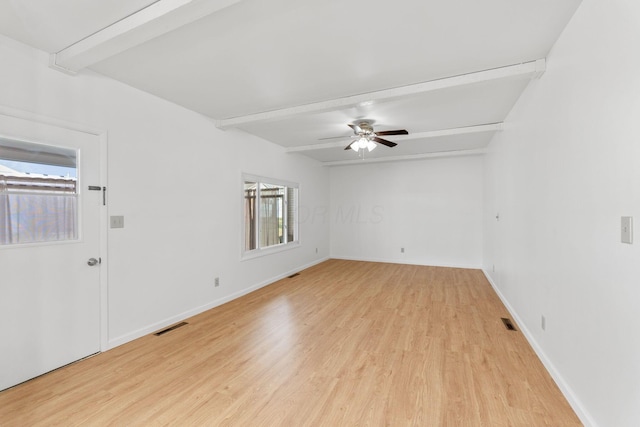 unfurnished room featuring light wood-type flooring, baseboards, visible vents, and beam ceiling