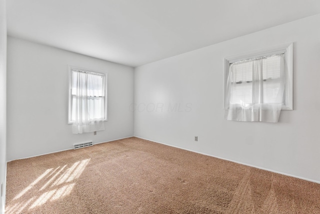 empty room featuring carpet and visible vents