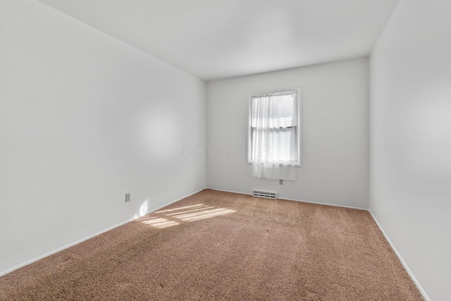 empty room featuring carpet floors and visible vents