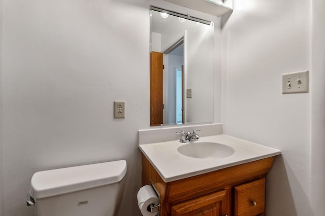 half bathroom with vanity and toilet