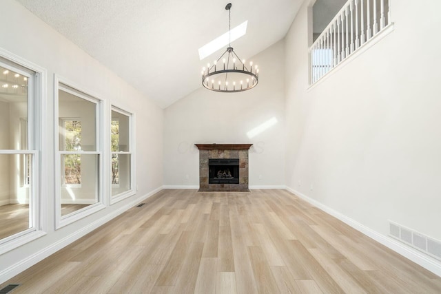 unfurnished living room with baseboards, visible vents, light wood-style flooring, and a tiled fireplace