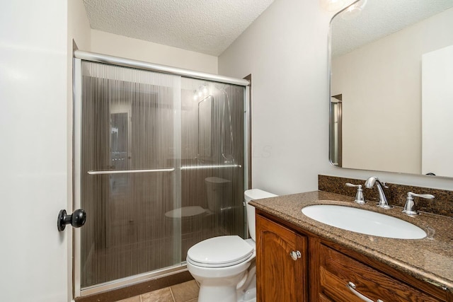 bathroom with toilet, a stall shower, a textured ceiling, and vanity