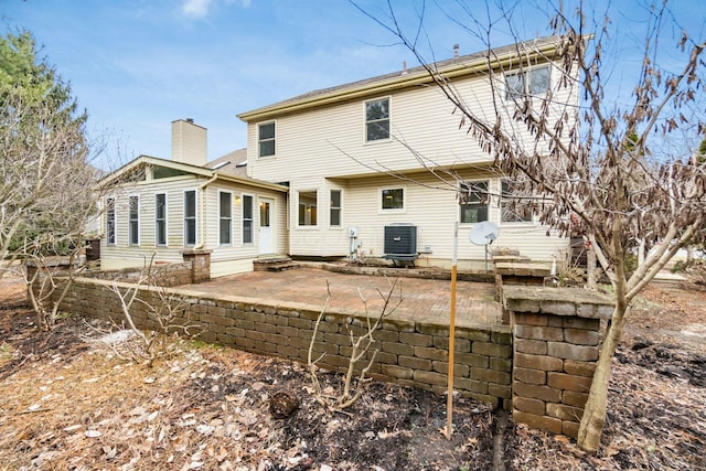 back of property featuring entry steps, a patio, a chimney, and central air condition unit