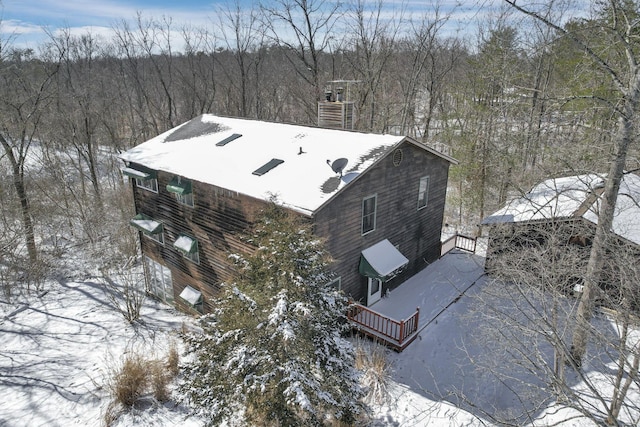 snowy aerial view featuring a wooded view