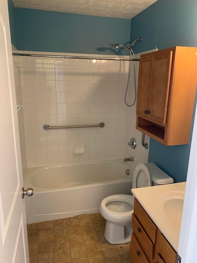 full bath featuring shower / bath combination, a textured ceiling, toilet, and vanity