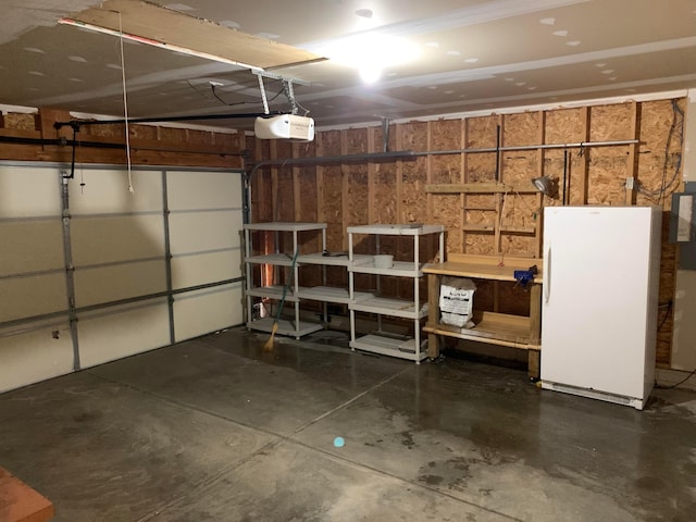 garage with a garage door opener and freestanding refrigerator