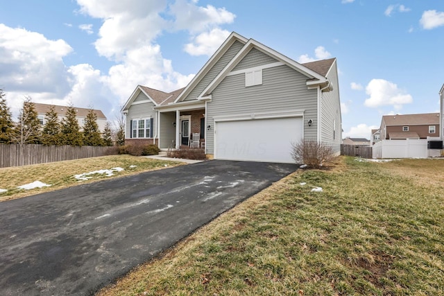 view of front facade with aphalt driveway, a porch, fence, a garage, and a front lawn