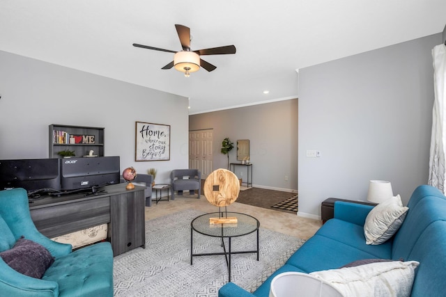 living room featuring light carpet, ornamental molding, a ceiling fan, and baseboards