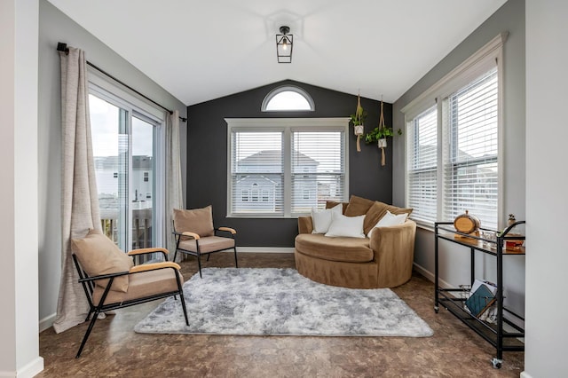 living area with lofted ceiling, plenty of natural light, and baseboards