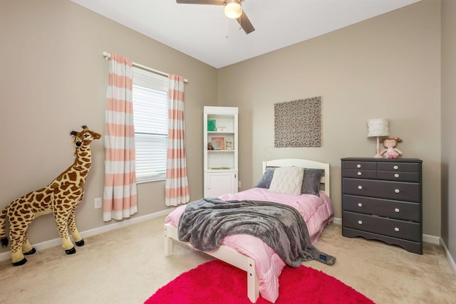 bedroom featuring light carpet, baseboards, and a ceiling fan