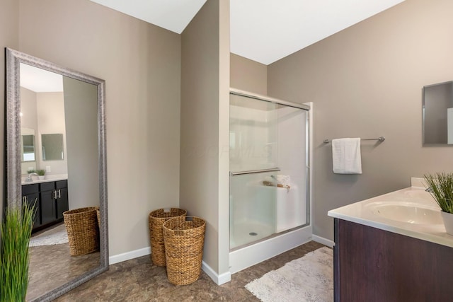 bathroom with a shower stall, vanity, and baseboards