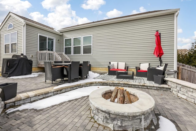 rear view of house featuring an outdoor living space with a fire pit, fence, and a patio