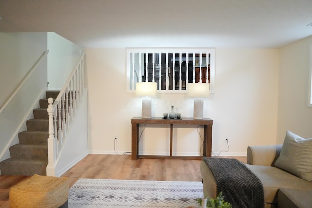 interior space featuring baseboards, stairway, and light wood finished floors