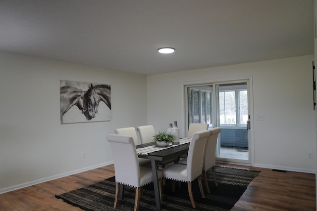 dining area featuring baseboards and wood finished floors