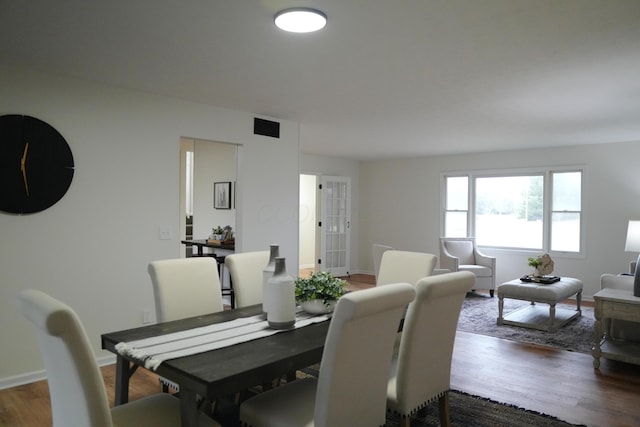 dining room featuring dark wood-style flooring, visible vents, and baseboards