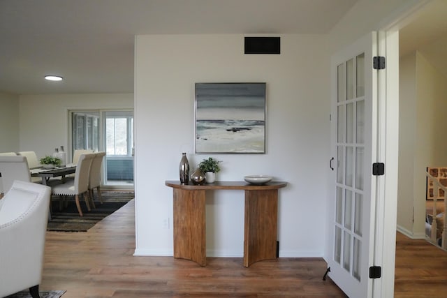 hallway featuring recessed lighting, visible vents, baseboards, and wood finished floors