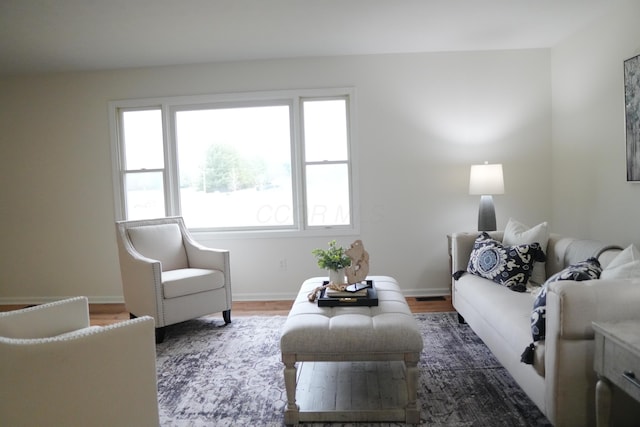 living room with dark wood-style floors, visible vents, and baseboards