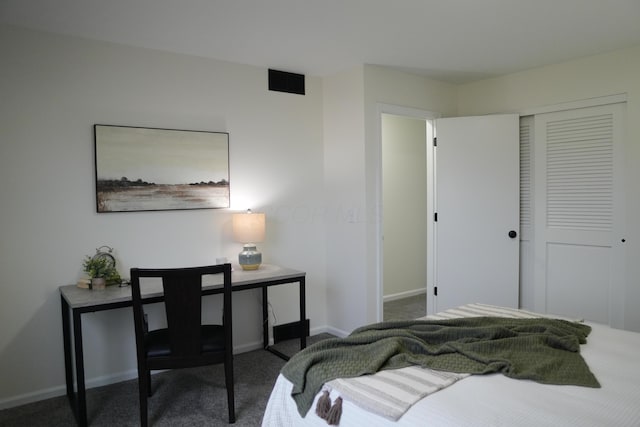 bedroom with a closet, dark carpet, and baseboards