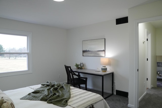 bedroom with dark carpet and baseboards