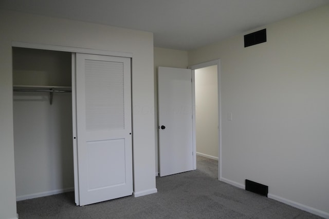 unfurnished bedroom featuring carpet floors, a closet, visible vents, and baseboards