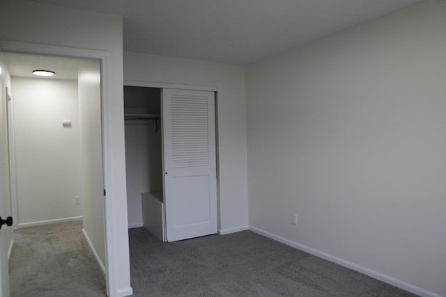 unfurnished bedroom featuring a closet, carpet flooring, and baseboards