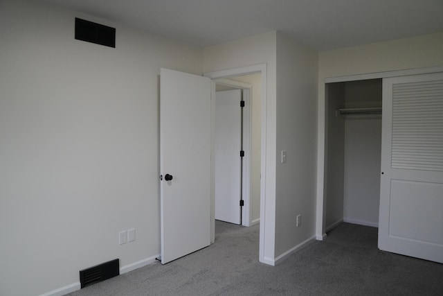 unfurnished bedroom with baseboards, visible vents, a closet, and light colored carpet