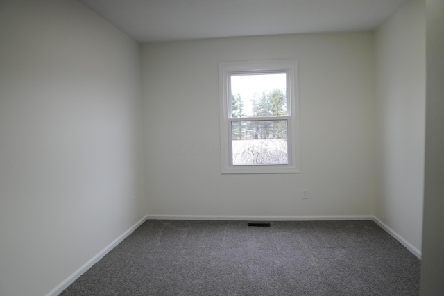 carpeted empty room featuring visible vents and baseboards