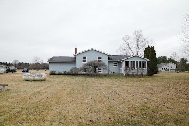 back of house with a sunroom, a lawn, and a chimney