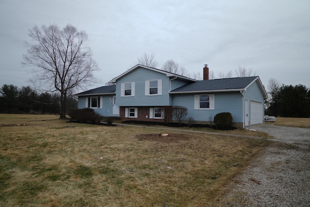 tri-level home with a front lawn, driveway, a chimney, and an attached garage