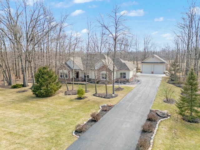 view of front facade with a garage, an outbuilding, and a front lawn