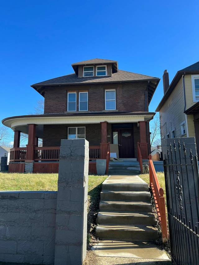 traditional style home with covered porch, fence, and brick siding