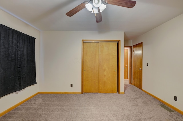 unfurnished bedroom with carpet floors, a closet, visible vents, ceiling fan, and baseboards