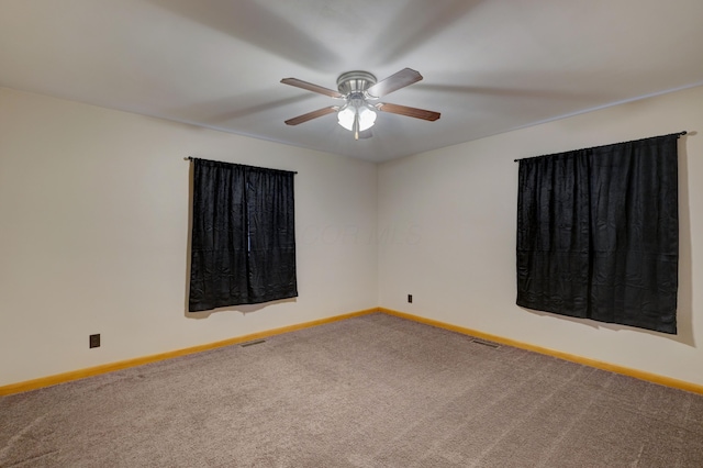 spare room featuring ceiling fan, carpet, visible vents, and baseboards