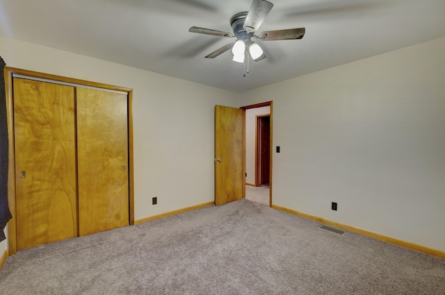 unfurnished bedroom with baseboards, visible vents, a ceiling fan, carpet floors, and a closet