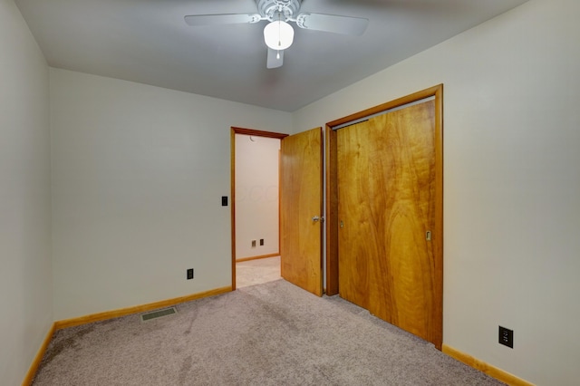 unfurnished bedroom with carpet, a closet, visible vents, a ceiling fan, and baseboards